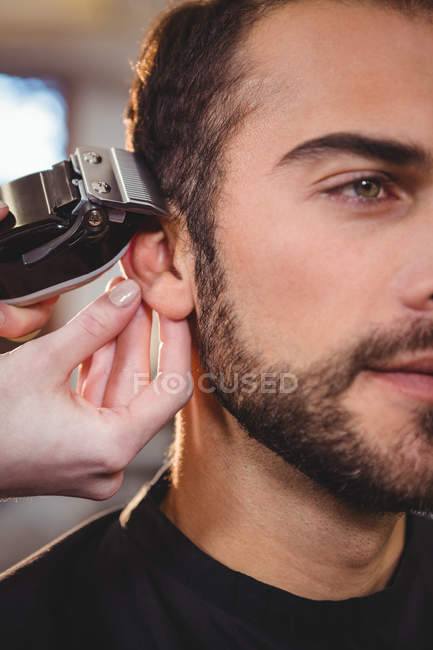 Abgeschnittenes Bild eines Mannes, der sich im Friseursalon die Haare schneiden lässt — Stockfoto