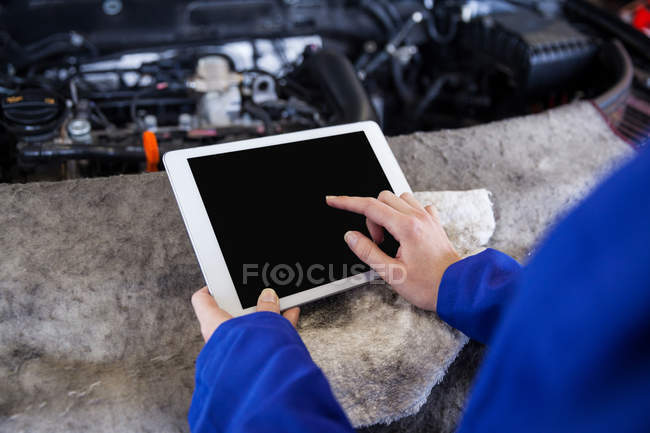 Imagen recortada de mecánico utilizando tableta digital en el garaje de reparación - foto de stock