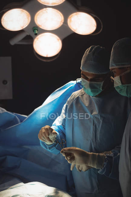 Male surgeons discussing while operation in operation room at hospital — Stock Photo