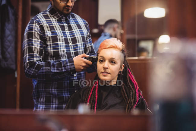 Donna ottenere i capelli tagliati con trimmer in negozio di barbiere — Foto stock