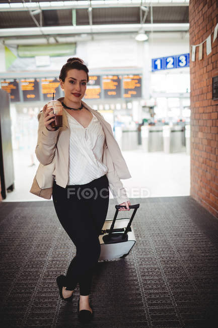 Retrato de comprimento total de mulher transportando bagagem na estação ferroviária — Fotografia de Stock