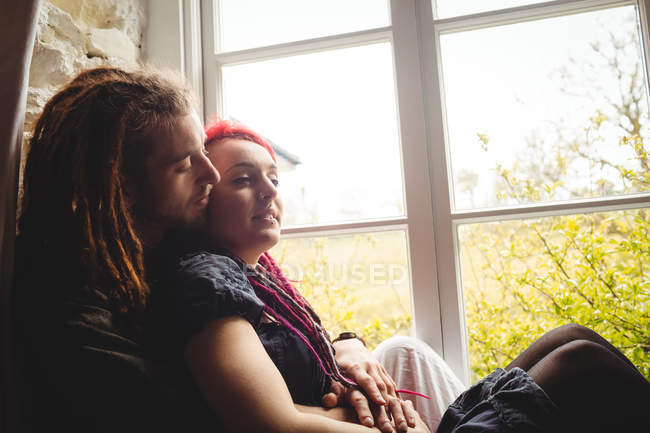Молода пара хіпстерів сидить біля вікна вдома — стокове фото