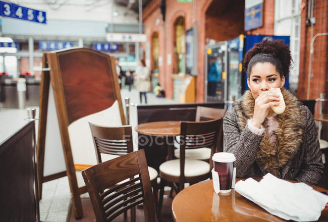 Femme qui mange du pain assis à table au restaurant — Photo de stock