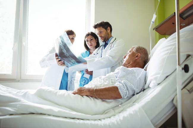 Médicos que interagem por radiografia relatam com o paciente no hospital — Fotografia de Stock