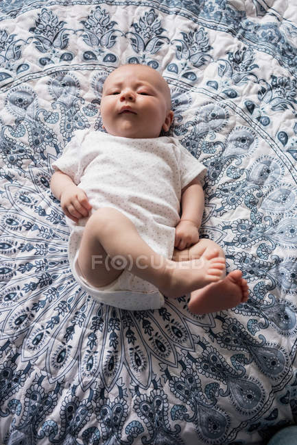 Baby lying on bed in bedroom at home — Stock Photo