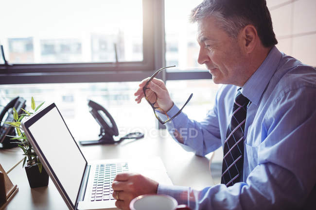 Uomo d'affari che lavora su laptop in ufficio — Foto stock