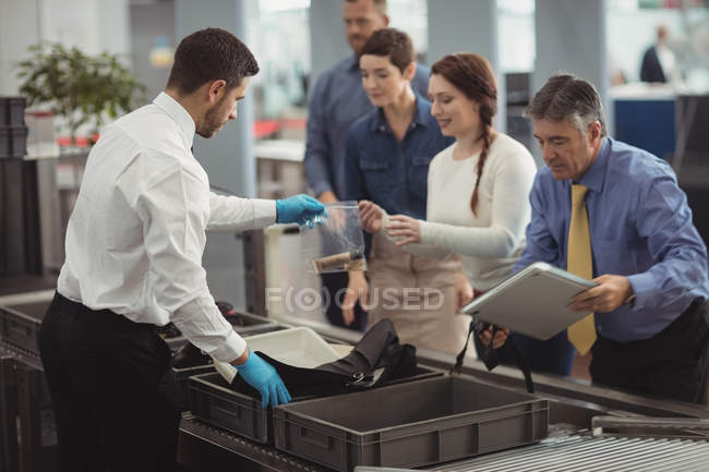 Commuters coletando sacos do balcão de segurança no aeroporto — Fotografia de Stock