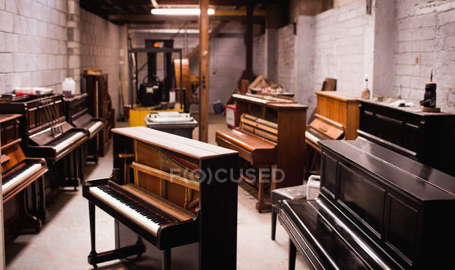 Pianos vintage disposés à l'intérieur de l'atelier — Photo de stock