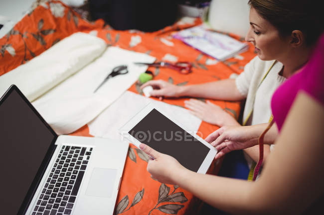 Дизайнери жіночої моди працюють на ноутбуці в студії — стокове фото