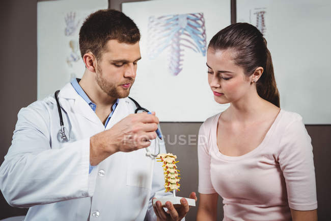 Фізіотерапевт, пояснюючи хребта, жіночий пацієнта в клініку — стокове фото