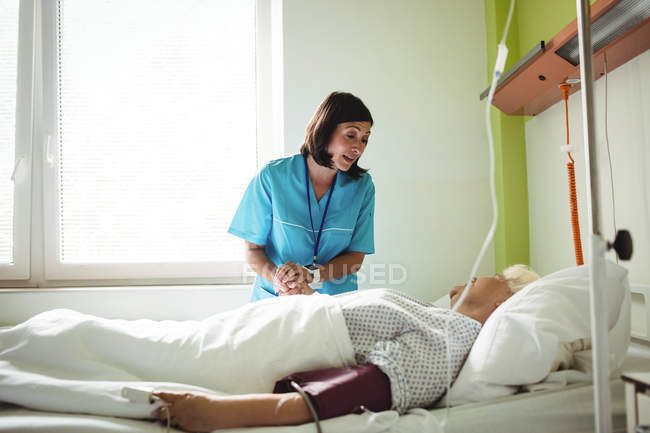 Nurse consoling senior patient in hospital — Stock Photo