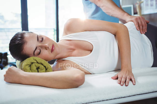 Чоловічий фізіотерапевт дає масаж стегна пацієнтці в клініці — стокове фото