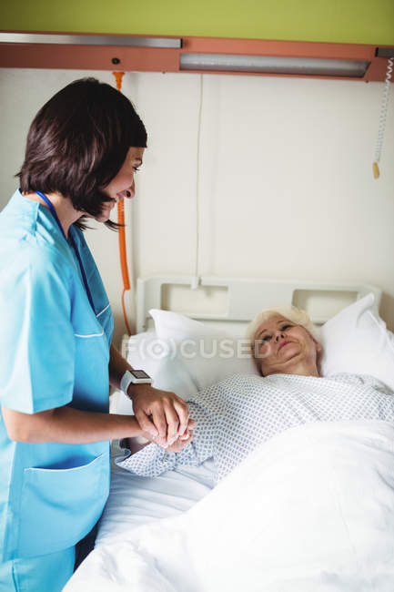 Медсестра утешает пожилого пациента в больнице — стоковое фото