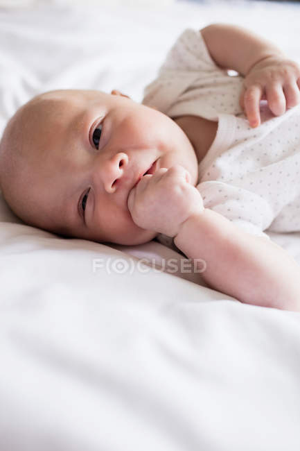 Primer plano de adorable bebé en la cama en casa - foto de stock