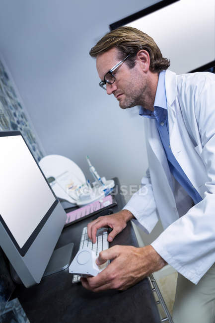 Dentist working on computer at dental clinic — Stock Photo