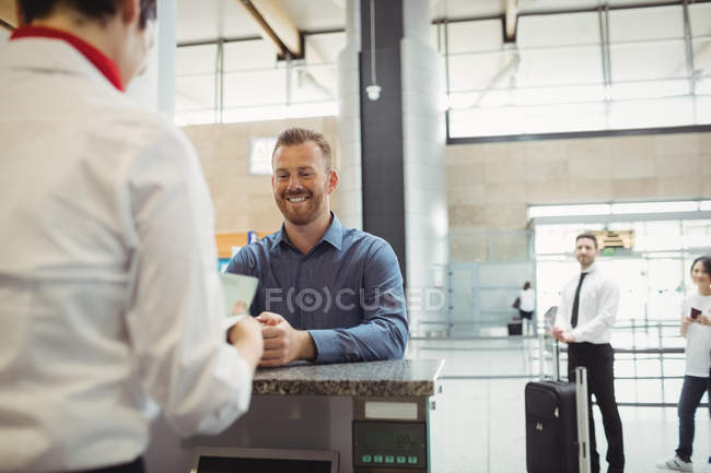 Flugbegleiter kontrollieren am Flughafen-Check-in-Schalter den Reisepass des Passagiers — Stockfoto
