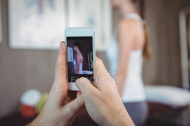 Physiotherapist clicking photo of female patient in clinic — Stock Photo