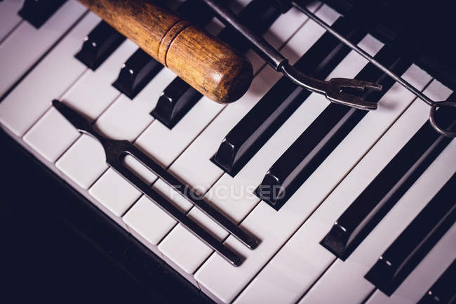 Крупный план ремонтных инструментов на старой фортепианной клавиатуре — стоковое фото