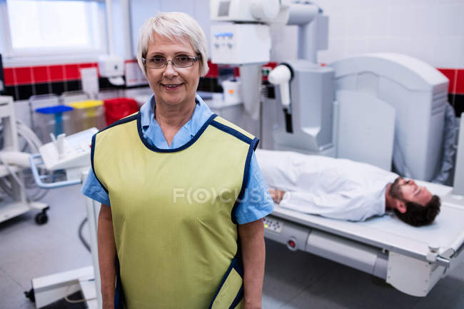 Портрет улыбающегося врача, стоящего в рентгеновской палате в больнице — стоковое фото