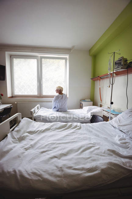Femme âgée assise sur le lit dans la salle d'hôpital — Photo de stock
