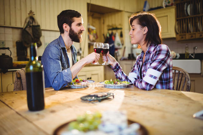 Couple ayant du vin et dîner à la maison — Photo de stock