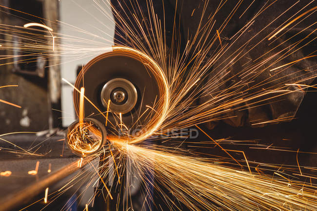 Обрізане зображення ріжучого металу зварювальника з електричним інструментом в майстерні — стокове фото