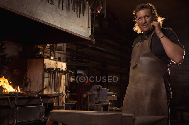 Portrait of blacksmith in protective work wear at work shop — Stock Photo