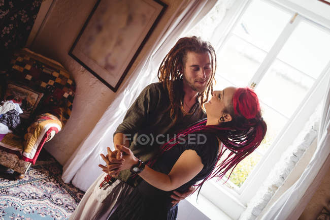 Giovane coppia che balla alla finestra a casa — Foto stock