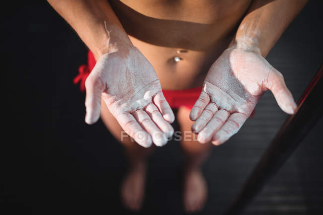 Cropped image of pole dancer with powder on hands in fitness studio — Stock Photo