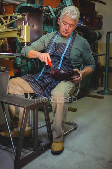 Shoemaker repairing a shoe in workshop — Stock Photo