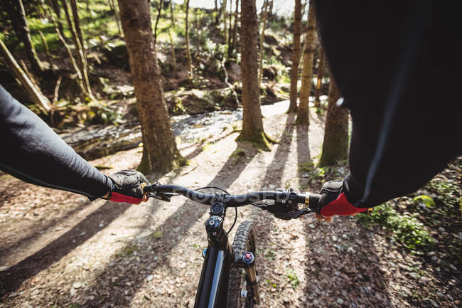 Cropped image of mountain biker riding in forest — Stock Photo