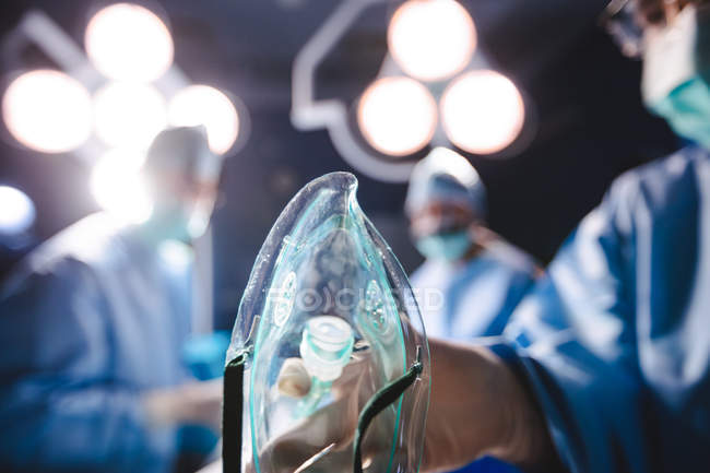 Cirurgião segurando máscara de oxigênio na sala de operação no hospital — Fotografia de Stock