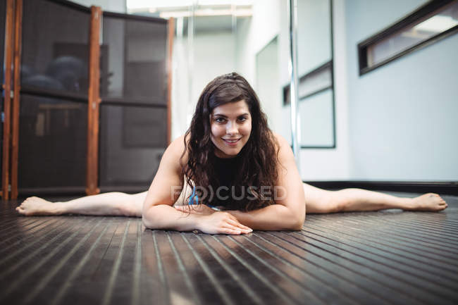 Portrait of pole dancer lying on floor in fitness studio — Stock Photo