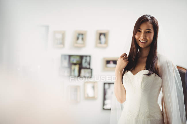 Portrait of smiling woman trying on wedding dress in shop — Stock Photo