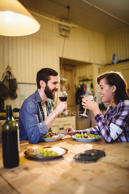 Пара має вино і вечерю вдома — стокове фото