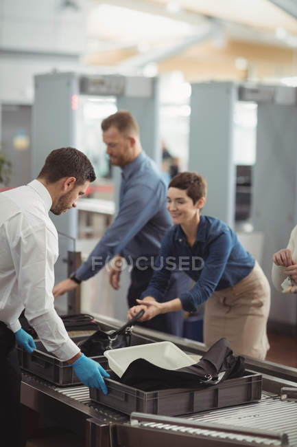 Комп'ютери, які збирають свої сумки з лічильника безпеки в аеропорту — стокове фото