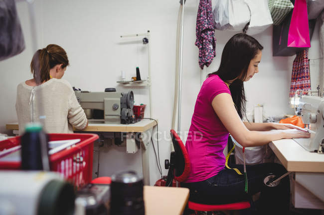 Stilisti di moda femminili che lavorano su computer portatile in studio — Foto stock