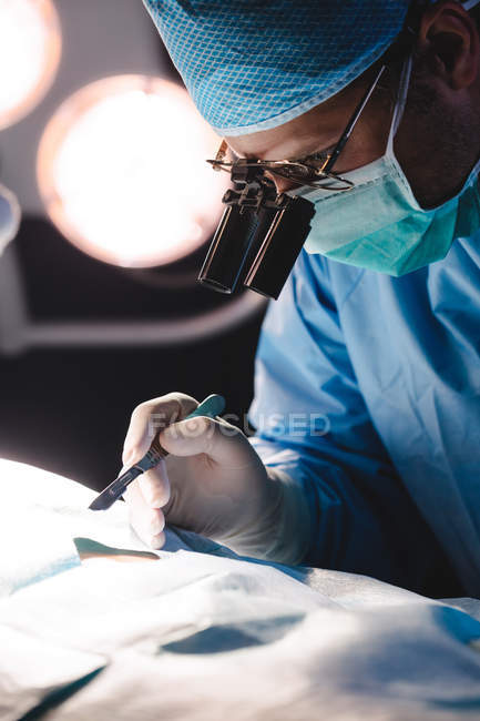 Cirurgião realizando operação em sala de operação no hospital — Fotografia de Stock