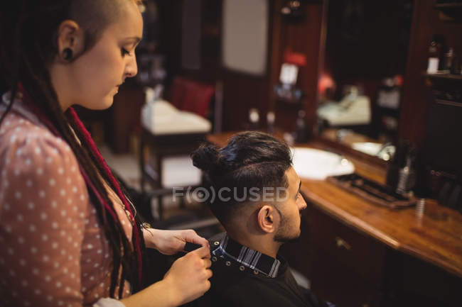 Female barber removing client apron in barber shop — Stock Photo