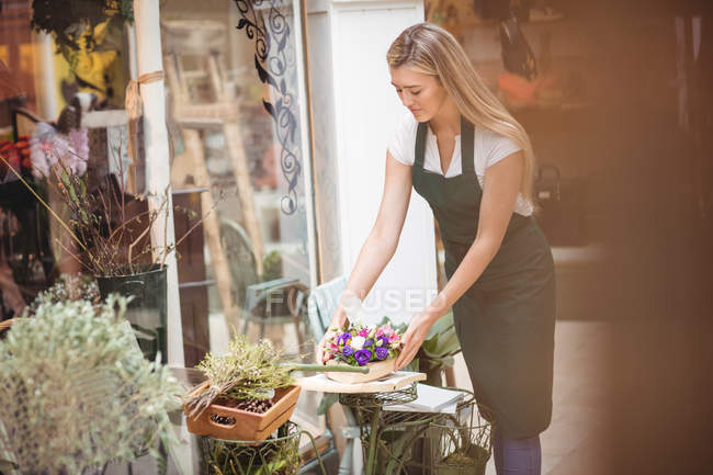 Florista feminina organizando buquê de flores em stand de exibição de flores na loja de flores — Fotografia de Stock