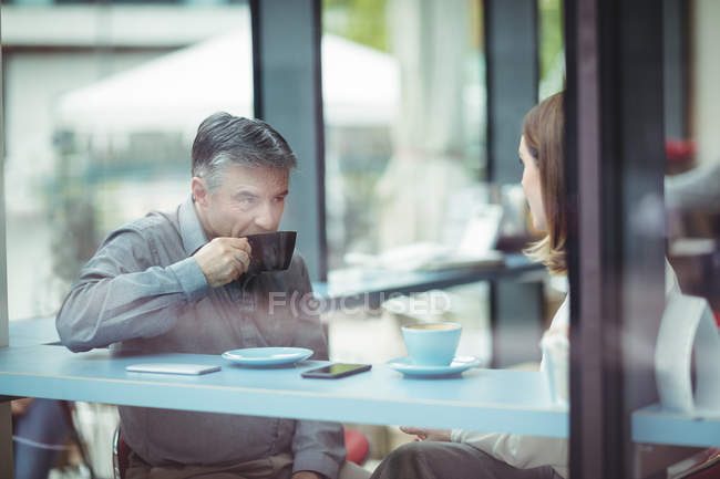 Homme et femme prenant un café à la cafétéria — Photo de stock