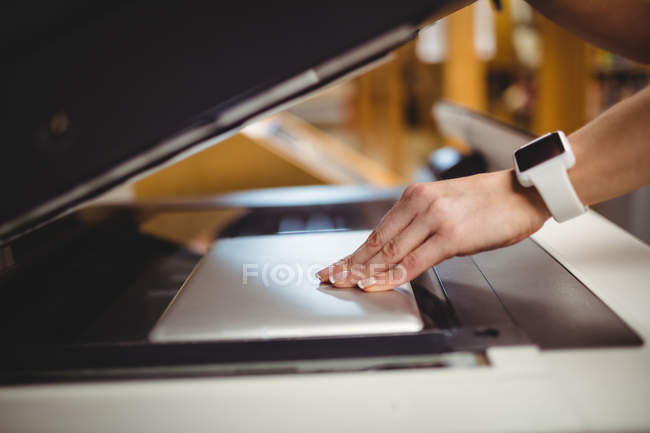 Cropped image of woman placing digital tablet on copy machine in library — Stock Photo