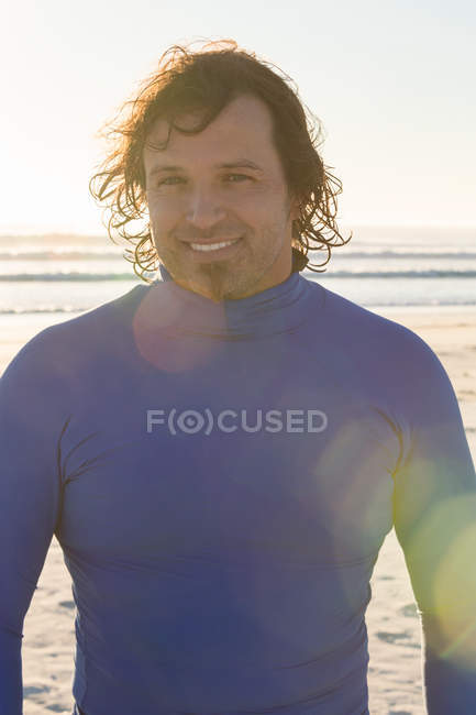 Surfista sorrindo para a câmera na praia — Fotografia de Stock