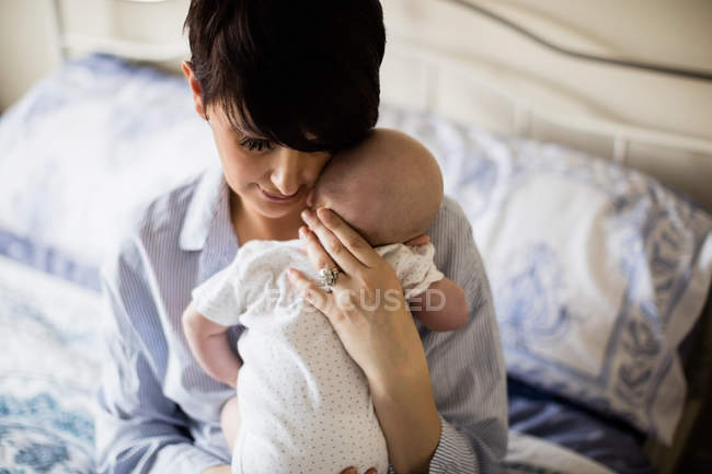 Mother holding baby while he sleeping in bedroom at home — Stock Photo