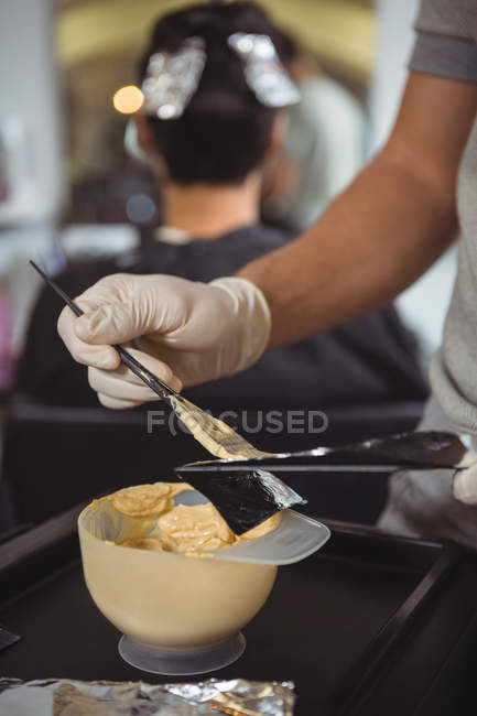 Midsection of female hairdresser preparing bowl of hair dye in salon — Stock Photo