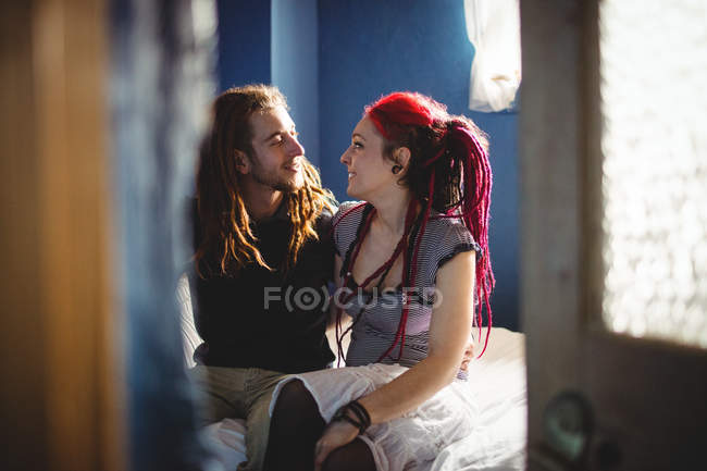 Jovem casal hipster sentado na cama em casa — Fotografia de Stock