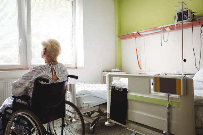 Старшая женщина, сидящая на инвалидной коляске в больнице — стоковое фото