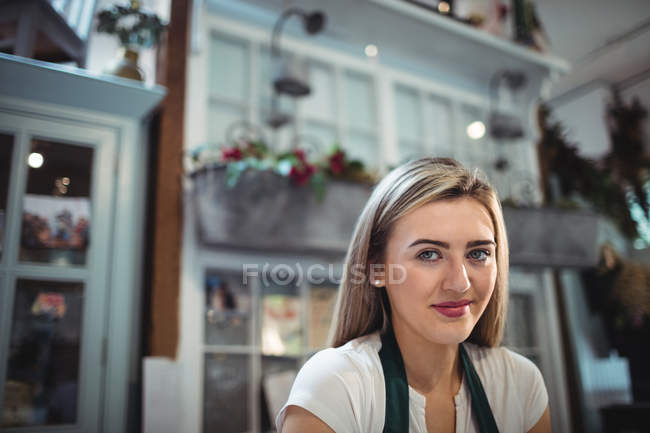 Портрет жіночого флориста, який посміхається в квітковому магазині — стокове фото