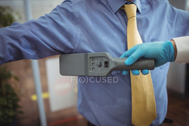 Oficial de segurança do aeroporto usando um detector de metais de mão para verificar um passageiro no aeroporto — Fotografia de Stock