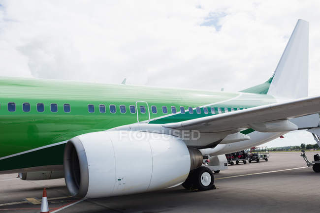 Airplane with loading bridge getting ready for departure at airport terminal — Stock Photo